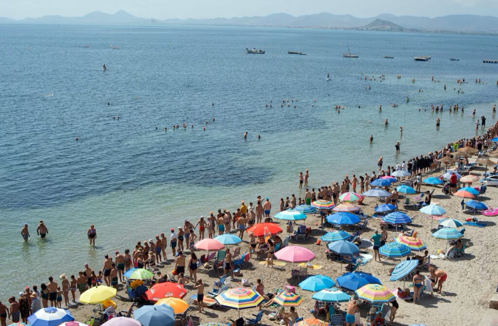 Cadena humana en defensa del mar Menor en una playa de este ecosistema murciano, en agosto de 2023