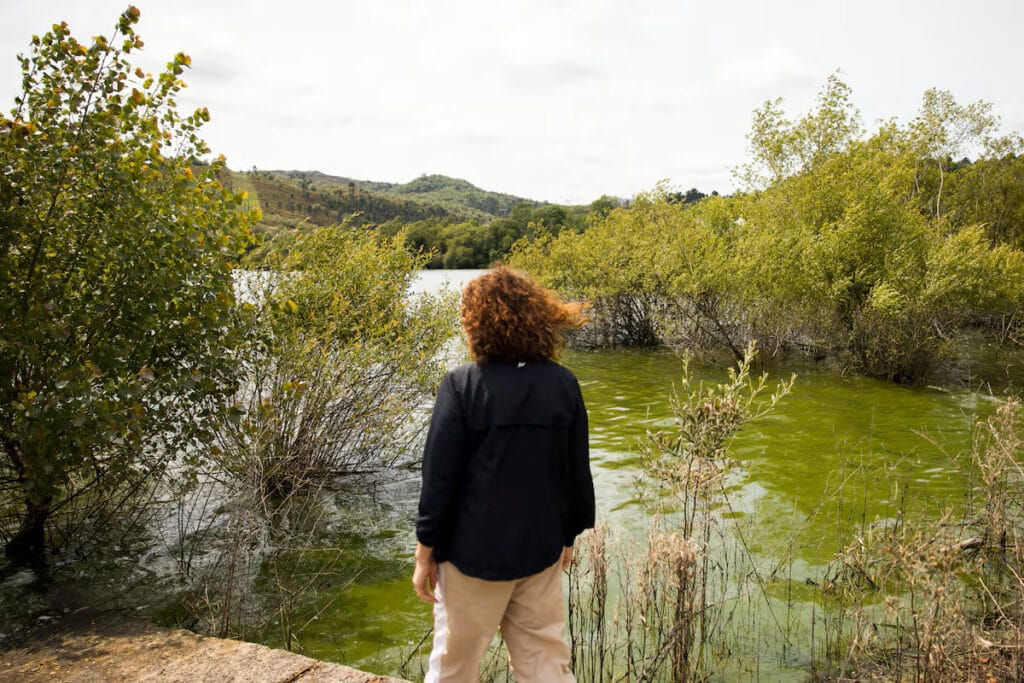Una vecina contempla el agua contaminada por cianobacterias en As Conchas -Lobeira. ÓSCAR CORRAL.