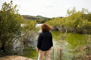 Una vecina contempla el agua contaminada por cianobacterias en As Conchas -Lobeira. ÓSCAR CORRAL.