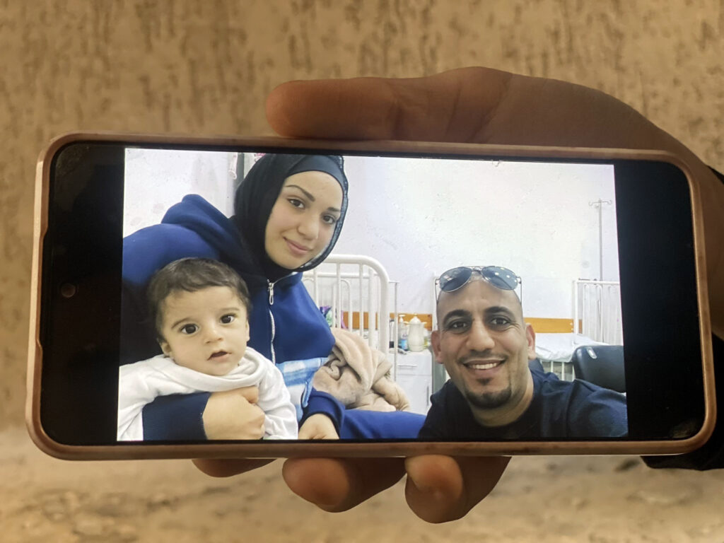 Ahmed Draimly muestra una fotografía de su familia antes de la muerte de su hijo, Zain, en su casa en el barrio de Al-Daraj de la ciudad de Gaza, el 20 de julio de 2025.