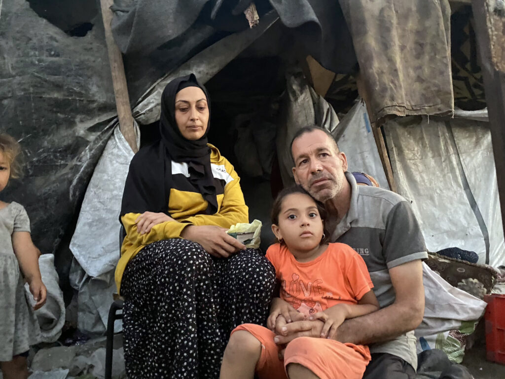 Wissal Marouf y su familia frente a su tienda de campaña en el estadio Al-Yarmouk, en el centro de la ciudad de Gaza, el 19 de julio de 2025.