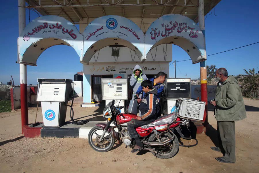 Un joven palestino llena una garrafa de combustible sentado en una moto en una gasolinera en Jan Yunis, en el sur de Gaza, en enero de 2015 -Foto - REUTERS - Ibraheem Abu Mustafa.
