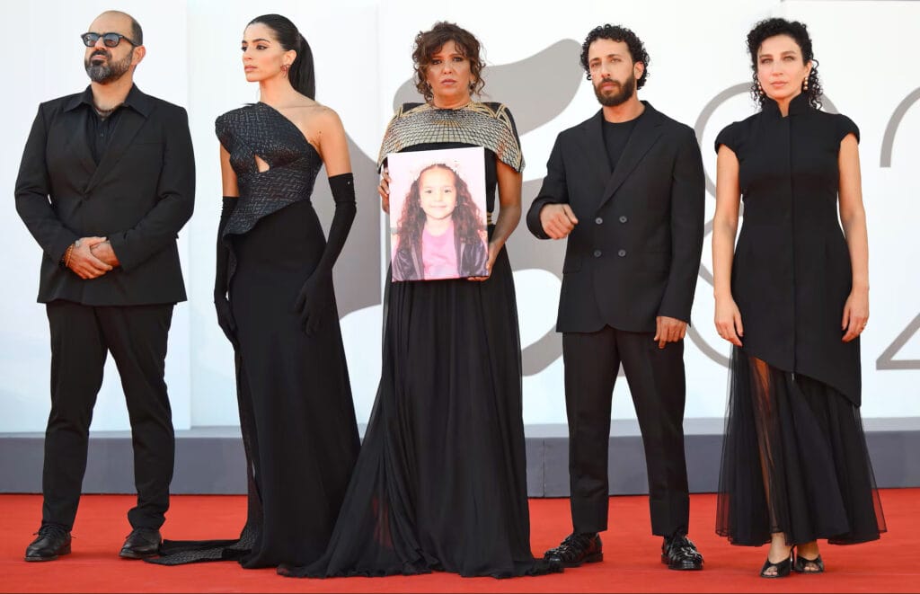 El equipo y los actores de la película 'La voz de Hind Rajab' posan en Venecia con la foto de la niña gazatí, el pasado 3 de septiembre - ETTORE FERRARI (EFE).
